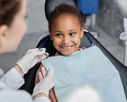 A young girl preparing for treatment at a dentist’s office